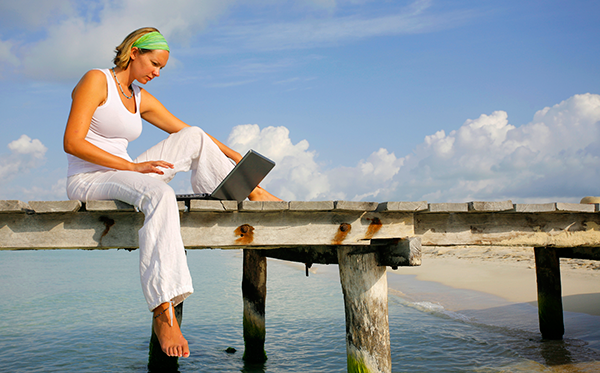 Kvinna laptop beach - Foto: Crestock