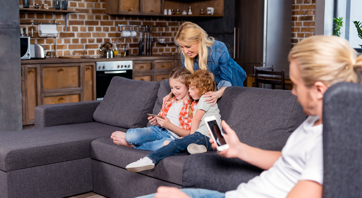 Family home sofa smartphone. Foto: Mostphotos.se