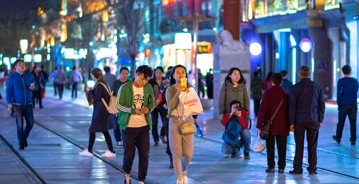 Människor promenerar längs den historiska Qianmen Street i Peking, Kina