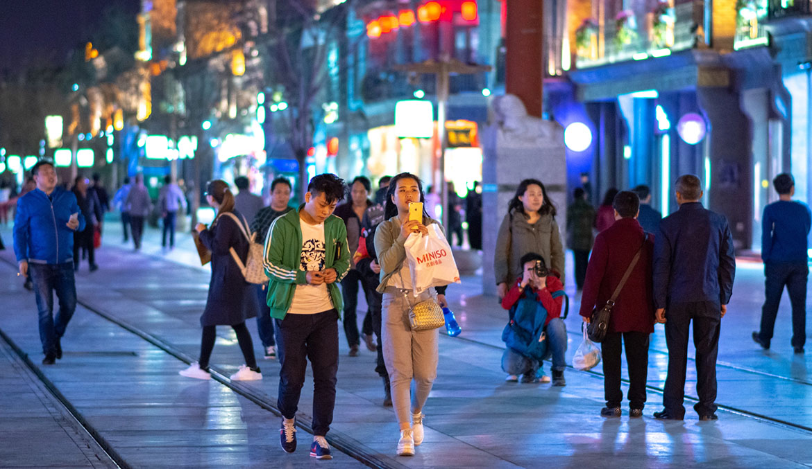 Människor promenerar längs den historiska Qianmen Street i Peking, Kina