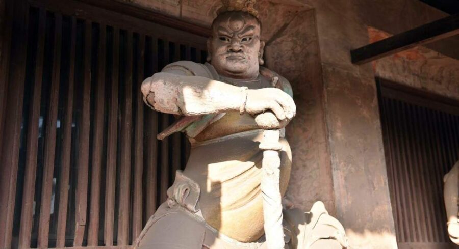 En skulptur av en av de fyra himmelska väktarna vid Shuanglin-templet