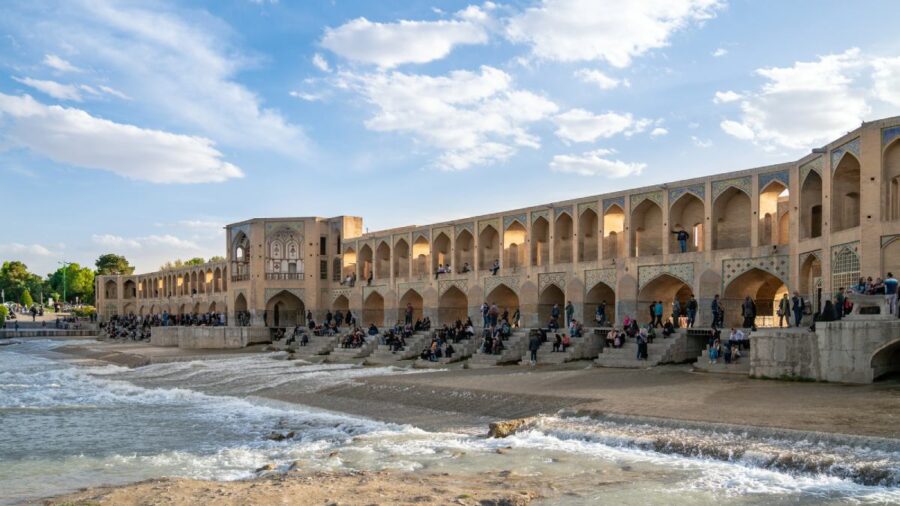 Iranian people passing time around Khaju bridge over Zayandeh river, Isfahan, Iran